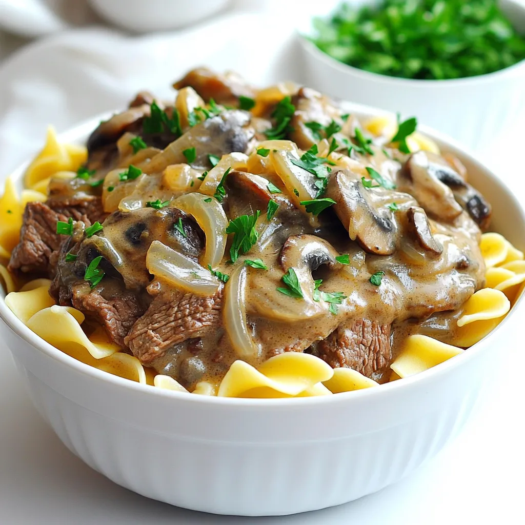 - 2 lbs beef chuck, cut into thin strips - 1 medium onion, chopped - 3 cloves garlic, minced - 8 oz mushrooms, sliced - 4 cups beef broth The main ingredients create a rich base for our beef stroganoff. Beef chuck offers a nice, tender bite after slow cooking. The onion and garlic give depth and warmth, while mushrooms add a savory touch. Beef broth ties it all together, ensuring a moist and flavorful dish. - 1 cup sour cream - 3 tablespoons Worcestershire sauce - 2 tablespoons Dijon mustard - 2 tablespoons all-purpose flour These sauce components create the creamy texture that defines stroganoff. Sour cream adds a tangy flavor. Worcestershire sauce gives it a savory kick. Dijon mustard enhances the taste, while flour thickens the sauce, making it perfect for coating the beef. - 1 tablespoon olive oil - Salt and pepper to taste - Egg noodles or rice (for serving) - Fresh parsley, chopped (for garnish) Seasoning is key to bringing out flavors. Use olive oil for browning the beef. Salt and pepper should be added to taste. Serve your beef stroganoff over egg noodles or rice for a complete meal. Fresh parsley adds color and a hint of freshness when you garnish your dish. Start with 2 lbs of beef chuck. Cut it into thin strips. Heat 1 tablespoon of olive oil in a large skillet over medium-high heat. Season the beef with salt and pepper. Brown the beef in batches for 2-3 minutes on each side. This step adds great flavor. Once browned, transfer the beef to your slow cooker. In the same skillet, add the chopped onion, minced garlic, and sliced mushrooms. Cook these for about 5 minutes. You want the onions to turn translucent and the mushrooms to soften. This mix brings out deep flavors in your dish. Sprinkle 2 tablespoons of all-purpose flour over the sautéed mixture. Stir for one minute. This helps cook the flour slightly. Next, add 4 cups of beef broth, 3 tablespoons of Worcestershire sauce, and 2 tablespoons of Dijon mustard. Stir well and bring it to a simmer for 2-3 minutes. Pour this sauce over the beef in the slow cooker. Mix everything together until it is well combined. Cover the slow cooker. Cook on low for 6-8 hours or on high for 3-4 hours. Check for tenderness; the beef should be soft and easy to pull apart. About 30 minutes before serving, stir in 1 cup of sour cream. This will make your sauce creamy and rich. Serve the beef stroganoff over egg noodles or rice, and add fresh parsley on top for a pop of color. To get tender beef in your stroganoff, start with good cuts. I recommend beef chuck. Cut it into thin strips. Browning the beef first helps lock in juices. Make sure to season it well with salt and pepper. Brown it in batches to avoid overcrowding. This step is key for a rich flavor. Once browned, transfer it to the slow cooker without delay. Adding spices can elevate your dish. Consider using garlic powder, onion powder, or paprika. Fresh herbs like thyme or rosemary also work well. These will give your stroganoff depth. Use them in small amounts first, then adjust to taste. Worcestershire sauce is another great addition. It adds a savory note that complements the beef. For a creamier sauce, adjust the sour cream amount. If you like it richer, add more sour cream. For a lighter dish, use less. Stir it in about 30 minutes before serving. This gives it time to blend with the other flavors. Mixing well ensures a smooth sauce. Serve over egg noodles or rice. {{image_2}} You can swap out beef for chicken or turkey. Both options work great in slow cooker beef stroganoff. Use about 2 pounds of boneless, skinless chicken breasts or turkey thighs. Cook them like you would the beef. The chicken or turkey will soak up the yummy flavors, making a tasty meal. Just remember to adjust cooking times. Chicken cooks faster, so check it at 4 hours on low or 2 hours on high. Want a meatless stroganoff? You can easily make a vegetarian version. Replace the beef with hearty veggies like mushrooms and zucchini. Use 8 ounces of sliced mushrooms and 2 cups of diced zucchini. You’ll still use the same broth and sauce ingredients. The sour cream adds creaminess, making it rich and delicious. This version is perfect for anyone who loves veggies or wants a lighter dish. You can change the sauce base for unique flavors. Try using cream cheese instead of sour cream for a richer taste. Just add 8 ounces of cream cheese about 30 minutes before serving. This will give your stroganoff a creamy texture and deeper flavor. You could also use different broths. Vegetable or chicken broth can replace beef broth. These small changes can give your dish a fresh twist while keeping it comforting. To keep your beef stroganoff fresh, store it in an airtight container. Let it cool first. You can keep it in the fridge for up to three days. If you want to keep it longer, freeze it. Place it in a freezer-safe container or bag. Make sure to remove as much air as possible. This helps prevent freezer burn. When you're ready to enjoy your leftovers, reheat them gently. Use the stove on low heat for the best flavor. Stir often to avoid sticking. You can also use the microwave. Heat it in short bursts, stirring in between. This keeps the sauce creamy and delicious. Your beef stroganoff will last about three days in the fridge. If frozen, it can last up to three months. Just remember, the sooner you eat it, the better the taste! Always check for signs of spoilage before eating leftovers. Yes, you can. If you want a creamy texture without sour cream, try using Greek yogurt. It adds creaminess and tang. Another option is to use cream cheese. Just mix it in near the end of cooking for a rich feel. You can also substitute with heavy cream. This will give you a smooth sauce that tastes great. If your sauce is too runny, there are easy ways to thicken it. You can mix cornstarch with cold water to create a slurry. Stir this into your sauce and let it cook for a few more minutes. Another option is to add more flour. Just sprinkle it in and mix well. Let it cook longer, so the flour thickens the sauce. Beef stroganoff tastes amazing with several sides. Classic egg noodles are a great choice. They soak up the sauce well. You can also serve it over rice for a hearty meal. Other good options include mashed potatoes or roasted vegetables. A simple green salad can add freshness to your plate. In this article, we explored the basics of making beef stroganoff. We discussed key ingredients like beef chuck, onions, and mushrooms. The blog also covered methods for preparing, cooking, and storing your dish. Tips for enhancing flavors and variations for different diets were shared. Always remember, cooking is about being creative and having fun. With these steps and ideas, you're ready to make a great meal that everyone will enjoy. Enjoy cooking!