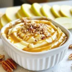 - 2 large apples (e.g., Granny Smith, Honeycrisp) - 1 cup caramel sauce (store-bought or homemade) - 1/2 teaspoon sea salt - 1/2 cup cream cheese, softened - 1/4 cup powdered sugar - 1 teaspoon vanilla extract - 1/4 cup chopped pecans (optional) - Additional sea salt for garnish For this salted caramel apple dip, you will need just a few simple ingredients. Start with two large apples. I love using Granny Smith or Honeycrisp because they are crisp and tart. This pairs perfectly with the sweet dip. Next, grab a cup of caramel sauce. You can use store-bought sauce or make your own if you feel adventurous. The choice is yours! You will also need some sea salt. Just half a teaspoon will do. This will give your dip that salty kick that balances the sweetness. The creamy base comes from half a cup of softened cream cheese. Make sure it’s soft for easy mixing. You’ll also need a quarter cup of powdered sugar. This adds sweetness and helps to fluff up the dip. Don’t forget one teaspoon of vanilla extract. It adds a lovely flavor. If you want, you can add chopped pecans. About a quarter cup will add a nice crunch. Lastly, keep some extra sea salt for garnish. It makes the dip look pretty and tastes great too! {{ingredient_image_1}} - First, take your softened cream cheese and place it in a bowl. - Add the powdered sugar and vanilla extract to the bowl. - Beat the mixture with an electric mixer until it is smooth and creamy. - Gradually pour the caramel sauce into the cream cheese mixture. - Keep mixing until everything is well blended. - Add the sea salt and stir gently. Taste it to see if you want more salt. - Transfer the dip into a nice serving bowl. - Drizzle extra caramel sauce on top for a sweet touch. - If you like, sprinkle chopped pecans around the edges. - Finish with a light sprinkle of sea salt on top. - Serve the dip with your sliced apples for dipping. Enjoy every bite! For the best dip, use crisp apples like Granny Smith or Honeycrisp. These varieties give a nice tartness that balances the sweet caramel. When selecting apples, look for ones that are firm and free of bruises. The skin should be smooth and shiny. Fresh apples will make your dip taste even better. You can easily change the flavor of your dip. Try adding a bit of cinnamon for warmth. You can also mix in other extracts, like almond or maple. For toppings, consider adding chocolate chips, crushed cookies, or toasted coconut. These will add fun textures and flavors. To make this dip, you will need a medium mixing bowl and an electric mixer. A spatula will help you scrape down the sides. For quick clean-up, have some paper towels handy to wipe down surfaces. If you use a non-stick bowl, it will make washing up easier. Pro Tips Choose the Right Apples: Opt for tart apples like Granny Smith or sweet ones like Honeycrisp to balance the flavors of the dip. Homemade Caramel Sauce: For a richer flavor, try making your own caramel sauce at home. It’s surprisingly easy and elevates the dip. Chill Before Serving: For the best texture, refrigerate the dip for 30 minutes before serving. This allows the flavors to meld beautifully. Presentation Matters: Serve the dip in a decorative bowl and garnish with extra caramel and pecans for an appealing look that invites guests to dig in. {{image_2}} You can change up the flavor of your salted caramel apple dip quite easily. Try adding a splash of different extracts, like almond or maple. These can give your dip a unique twist. Adding spices can also enhance the taste. A hint of cinnamon or nutmeg can really warm it up! You can even mix in different nuts. Chopped walnuts or hazelnuts can add a nice crunch. If you want a lighter version, opt for low-fat cream cheese. This choice keeps the creaminess while cutting down on fat. You can also look for sugar-free caramel options. Many brands offer these, making it easier to enjoy without the extra sugar. Just be sure to check the taste since some sugar-free products can differ in flavor. How you serve the dip can make a big difference! Use fun serving dishes, like small bowls or jars, to hold the dip. This adds a nice touch. You can layer the dip in a clear glass for a pretty view. For garnishes, try using a sprinkle of chopped pecans or a drizzle of extra caramel. A light dusting of sea salt on top can make it look fancy. These small details will impress your guests! To store your leftover salted caramel apple dip, place it in an airtight container. This keeps out air and moisture. Make sure to press plastic wrap against the dip before sealing the lid. This helps keep the dip fresh longer. If you want to warm the dip, use the microwave. Heat it in short bursts of 15 seconds. Stir between each burst to keep the dip smooth. Avoid overheating, as this can change the texture and flavor. In the refrigerator, your dip lasts three to five days. Look for any changes in smell or color. If it smells off or changes texture, it's best to throw it away. Always trust your senses when it comes to food safety. Yes, you can make this dip ahead of time. Prepare the dip and store it in the fridge. This keeps it fresh. I suggest covering it with plastic wrap. You can make it up to two days in advance. Just give it a quick stir before serving. The flavors will blend nicely over time. If you need a substitute for cream cheese, there are good options. You can use Greek yogurt for a tangy twist. Silken tofu works well for a dairy-free version. Another option is cashew cream, which is rich and creamy. These substitutes keep the dip smooth while adding different flavors. Making homemade caramel sauce is simple. Start by melting sugar in a pan over low heat. Stir constantly until it turns golden brown. Then, slowly add heavy cream while stirring. Be careful, as it can bubble. Allow it to cool before using. For a full recipe, check out my detailed caramel sauce guide. This blog post covered how to make a tasty salted caramel apple dip. You learned about the ingredients, step-by-step instructions, and useful tips. I shared ways to customize the dip and how to store it properly. Remember, using the right apples makes a big difference. Feel free to change flavors or toppings to fit your taste. Enjoy sharing this simple yet delicious dip at your next gathering. Happy dipping!